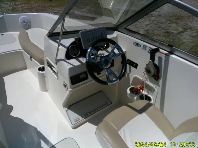 Slide: The Image of 2019 Stingray 191 Dual Console boat interior with steering wheel and Garmin navigation system. - 14