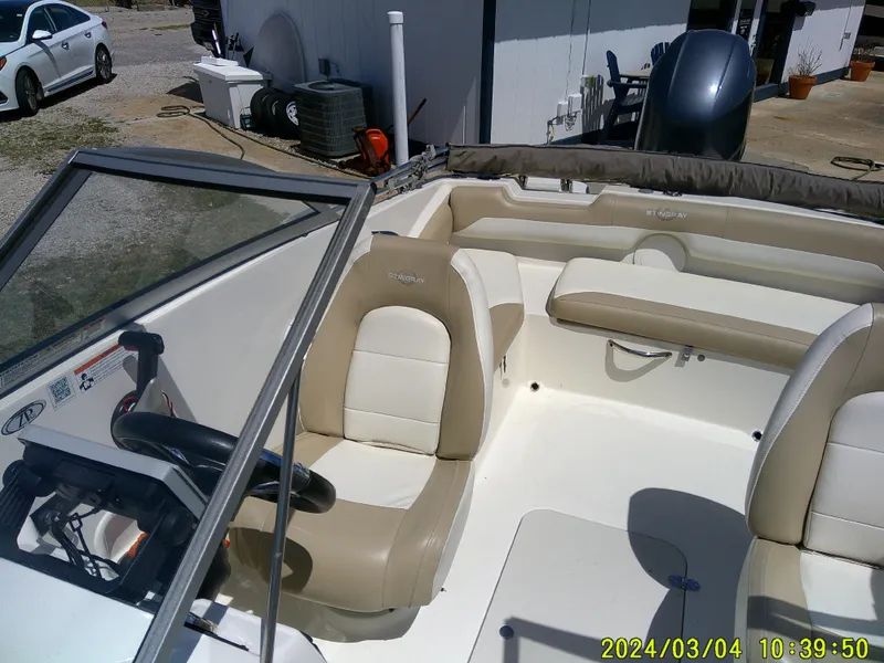 Slide: The Image of 2019 Stingray 191 Dual Console boat interior with beige seating and steering wheel. - 18