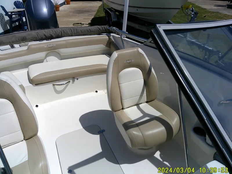 Slide: The Image of 2019 Stingray 191 Dual Console boat interior with beige seating and windshield. - 19