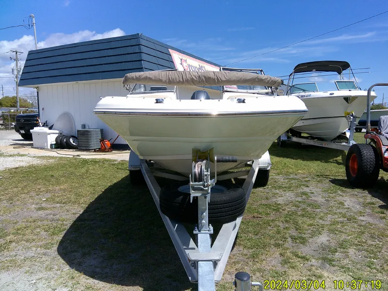 Slide: The Image of 2019 Stingray 191 Dual Console boat on trailer, parked outdoors near a building. - 3