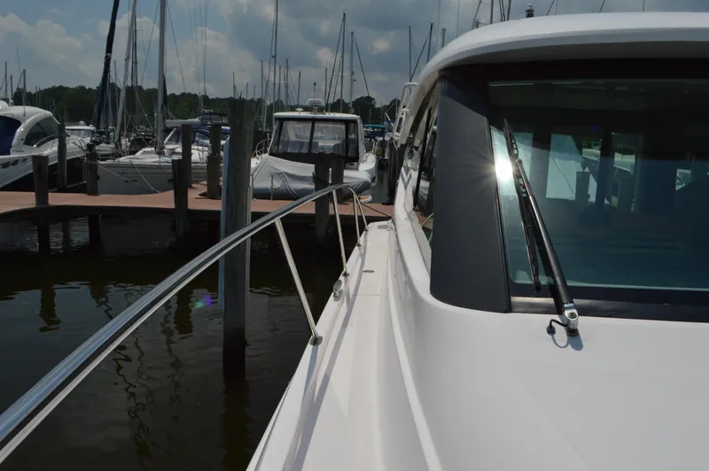 Slide: The Image of 2019 Tiara Yachts C39 Coupe docked at marina, side view with railing and windshield. - 14