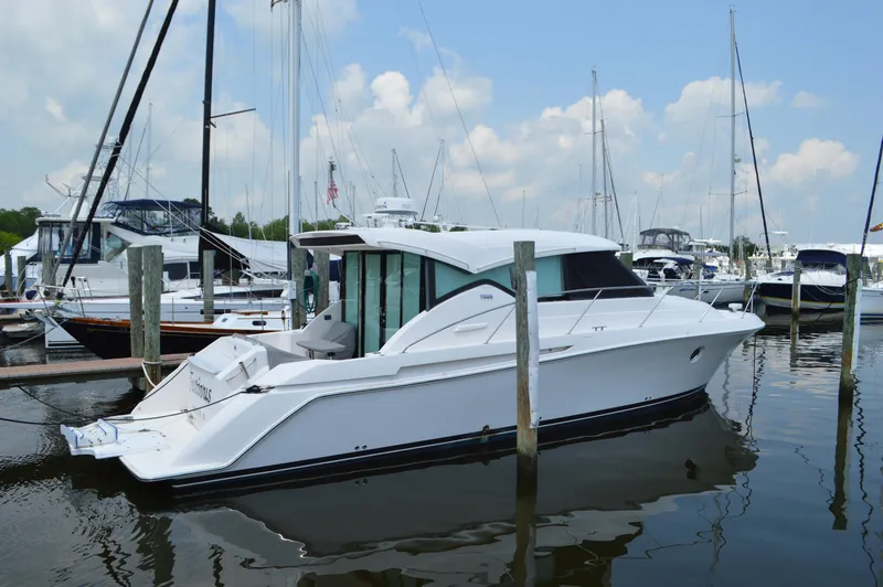 Slide: The Image of 2019 Tiara Yachts C39 Coupe docked in a marina under a partly cloudy sky. - 2