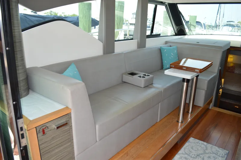 Slide: The Image of 2019 Tiara Yachts C39 Coupe interior with gray seating and wooden accents. - 29