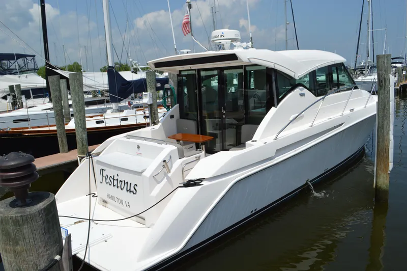Slide: The Image of 2019 Tiara Yachts C39 Coupe docked, rear view, white exterior, marina setting. - 5