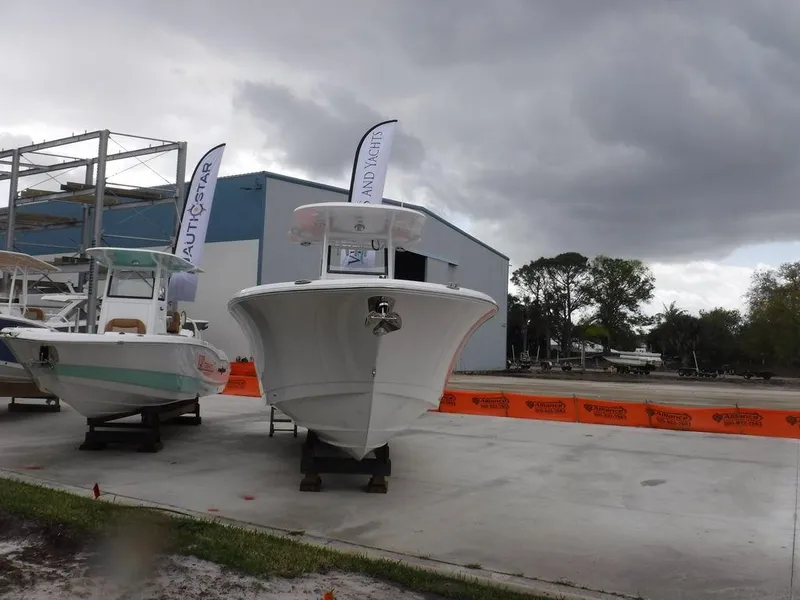 Slide: The Image of 2025 NauticStar 292 Legacy boat cruising in a marina, featuring dual engines. - 2