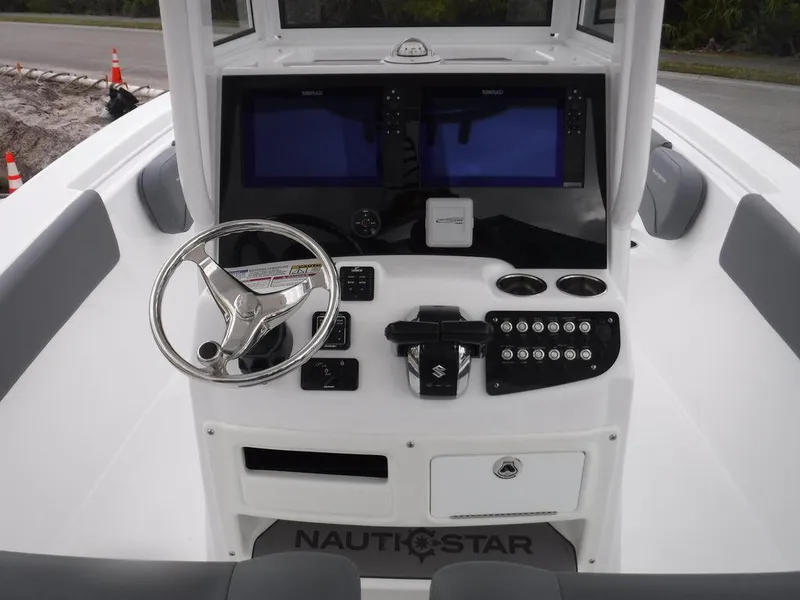 Slide: The Image of 2025 NauticStar 292 Legacy boat dashboard with dual screens and steering wheel. - 32