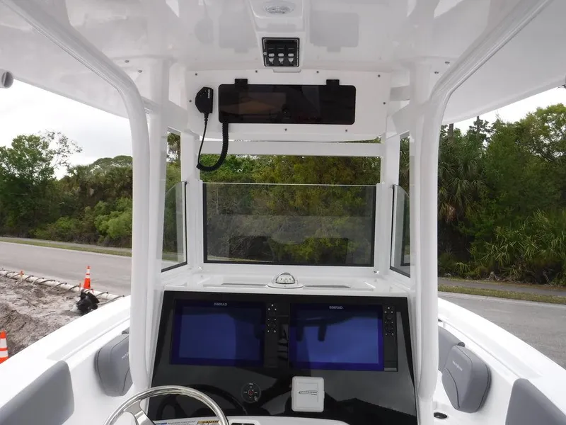 Slide: The Image of 2025 NauticStar 292 Legacy boat dashboard with dual screens and steering wheel. - 33