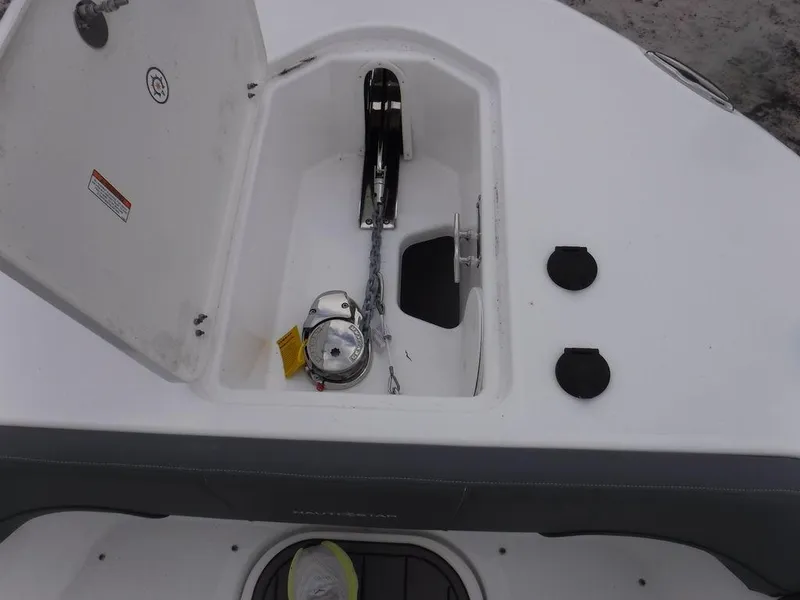 Slide: The Image of 2025 NauticStar 292 Legacy anchor compartment with open hatch and visible chain. - 37
