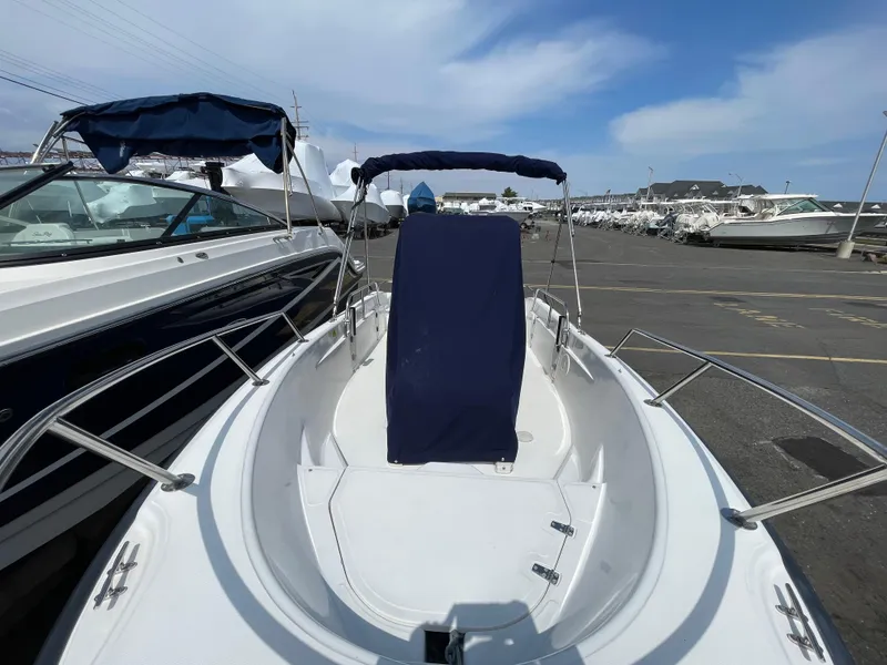 Slide: The Image of 1999 Boston Whaler 16 Dauntless boat with blue canopy, docked in a marina. - 3