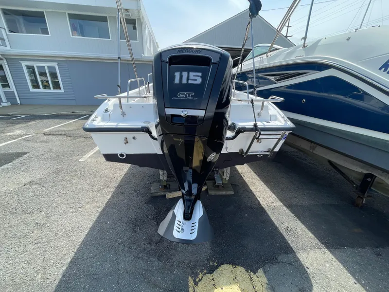 Slide: The Image of 1999 Boston Whaler 16 Dauntless with Mercury 115 outboard motor, parked in a marina. - 5