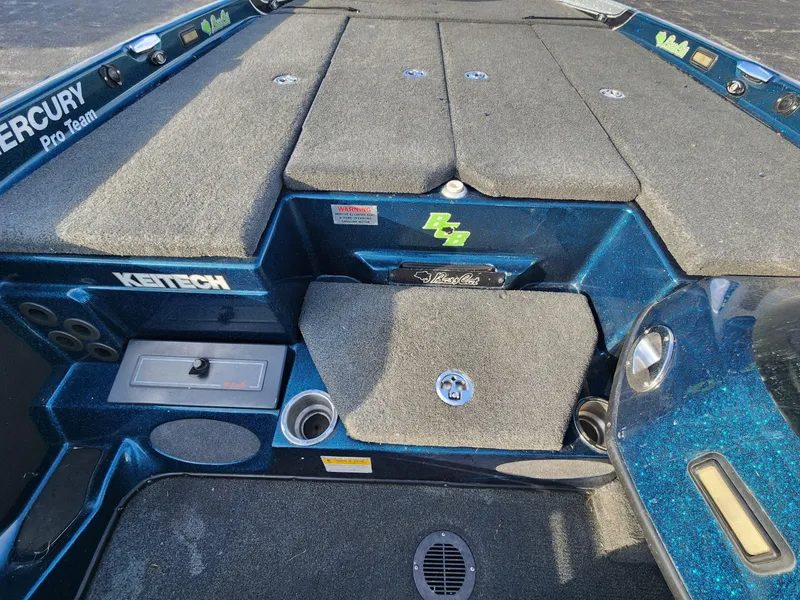 Slide: The Image of 2014 Bass Cat Eyra boat deck with storage compartments and fishing gear setup. - 12