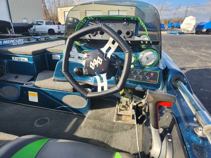 Slide: The Image of 2014 Bass Cat Eyra boat interior with steering wheel and dashboard controls. - 27