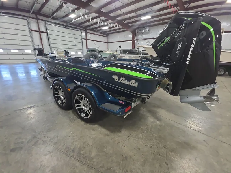 Slide: The Image of 2014 Bass Cat Eyra boat in a garage, featuring sleek design and powerful engine. - 3