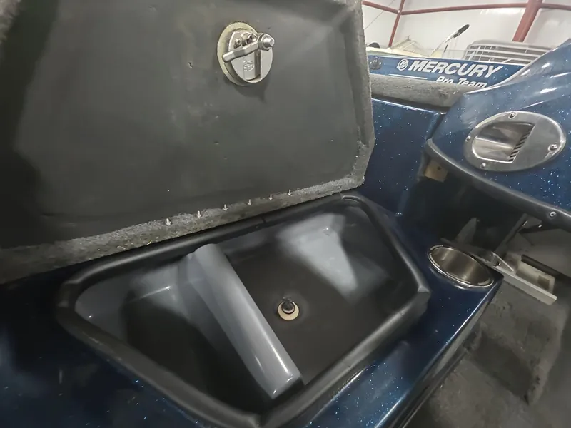 Slide: The Image of 2014 Bass Cat Eyra boat compartment with open lid and Mercury Pro Team branding. - 31