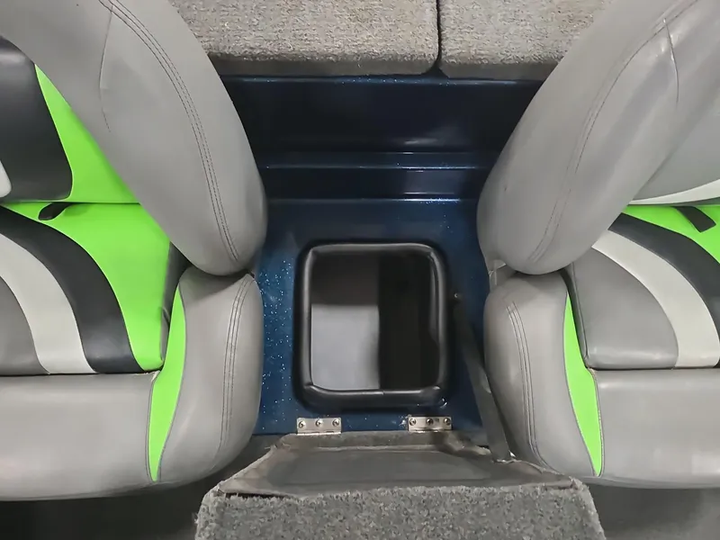 Slide: The Image of 2014 Bass Cat Eyra boat interior with gray and green seats, center storage compartment. - 32