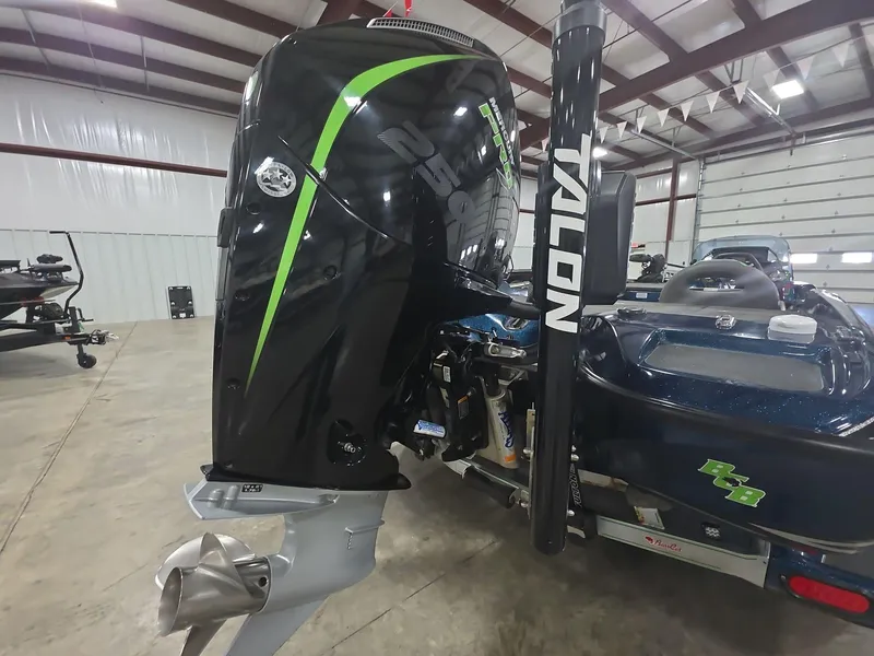 Slide: The Image of 2014 Bass Cat Eyra boat with Talon anchor and powerful outboard motor in a spacious garage. - 5