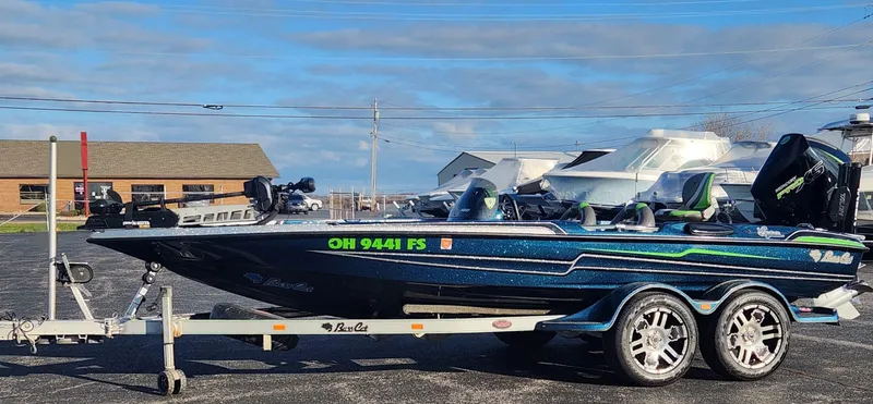 Slide: The Image of 2014 Bass Cat Eyra boat on trailer, parked outdoors under a clear sky. - 7
