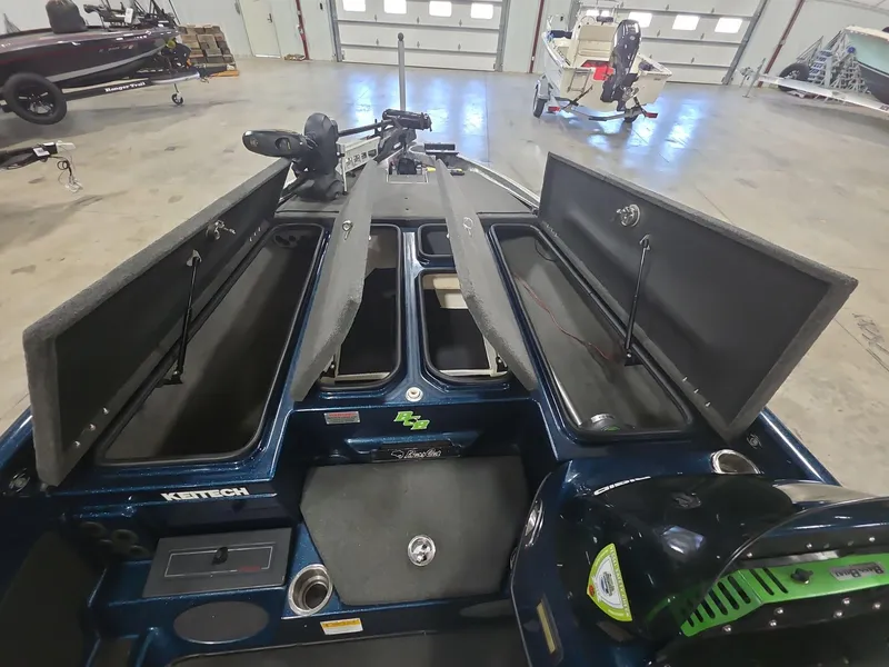 Slide: The Image of 2014 Bass Cat Eyra boat interior with open storage compartments in a garage setting. - 9