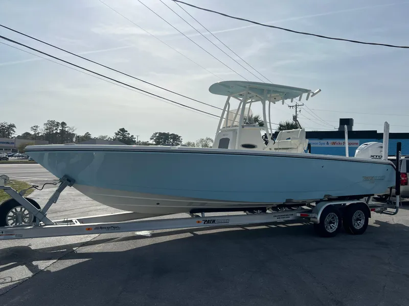 Slide: The Image of 2024 Pathfinder 2700 Open boat on trailer, light blue hull, parked outdoors. - 27