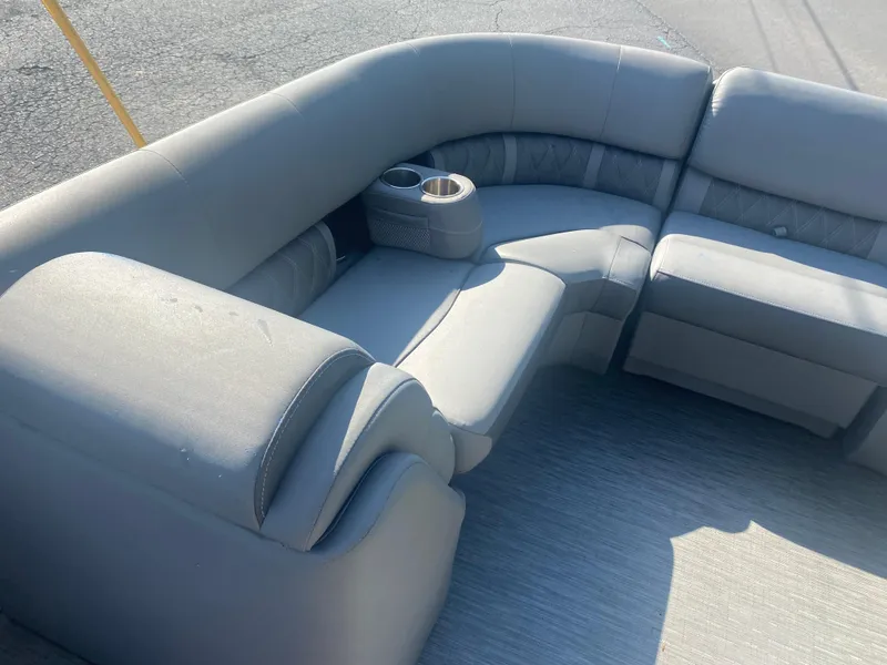 Slide: The Image of 2022 Bennington LX 24 Swingback boat interior with gray cushioned seating and cup holders. - 16