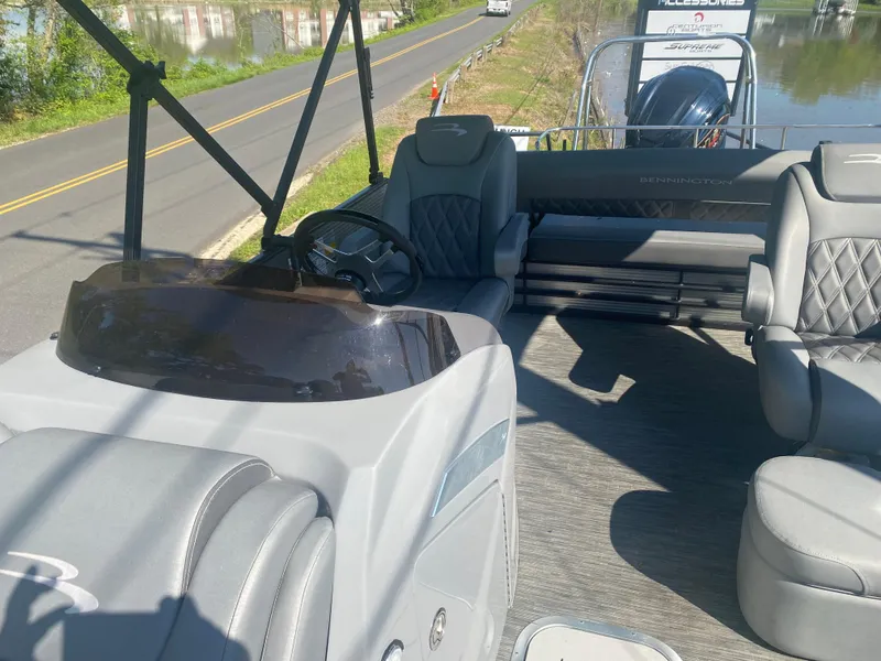 Slide: The Image of 2022 Bennington LX 24 Swingback boat interior with gray seating and steering console. - 6