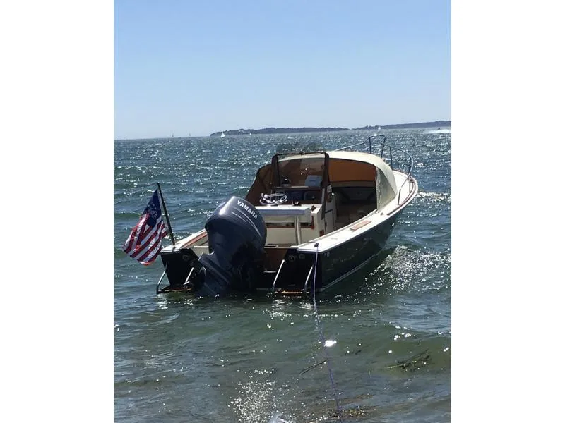 The Image of 1986 Padebco 21 boat with outboard motor, American flag, anchored in calm waters. - 0