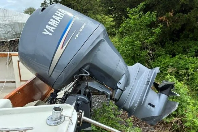 Slide: The Image of 1986 Padebco 21 boat with Yamaha outboard motor and American flag, docked in marina. - 10