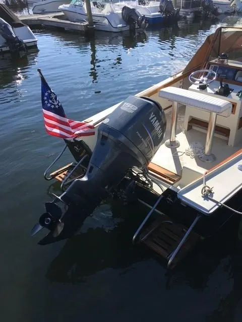 Slide: The Image of 1986 Padebco 21 boat with Yamaha outboard motor and American flag, docked in marina. - 3