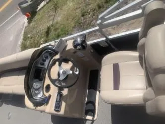 Slide: The Image of 2017 Sun Tracker Party Barge 24 DLX boat interior with steering console and beige seating. - 5