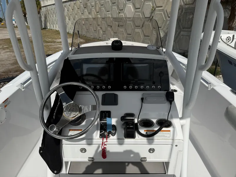 Slide: The Image of 2020 Sportsman Open 232 Center Console boat dashboard with steering wheel and controls. - 1
