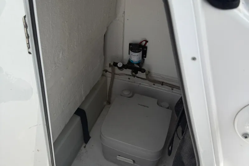 Slide: The Image of 2020 Sportsman Open 232 Center Console boat interior with portable toilet. - 8