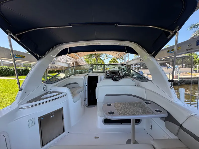 Slide: The Image of 2009 Chaparral Signature 290 boat interior with seating, table, and helm under canopy. - 13