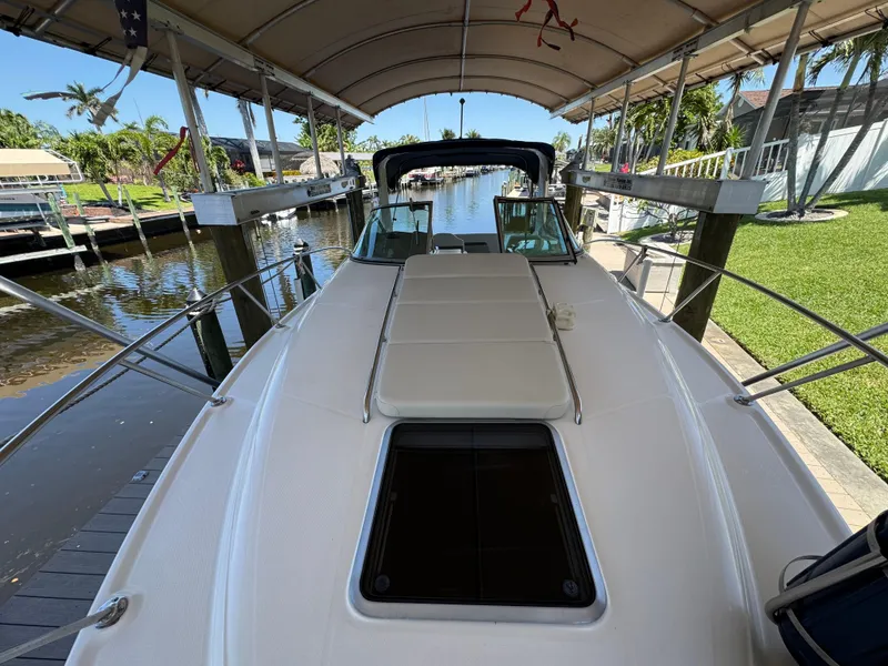 Slide: The Image of 2009 Chaparral Signature 290 boat docked under canopy, featuring spacious deck and sleek design. - 18