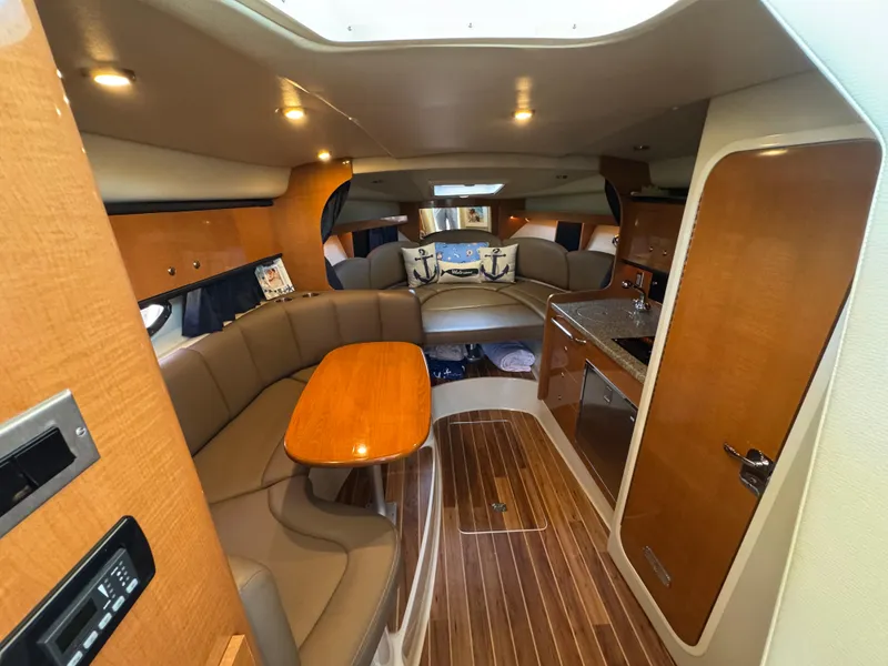 Slide: The Image of 2009 Chaparral Signature 290 interior with wood accents, seating, and kitchenette. - 20