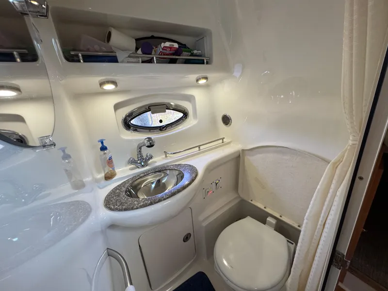 Slide: The Image of 2009 Chaparral Signature 290 bathroom with sink, toilet, and storage shelves. - 25