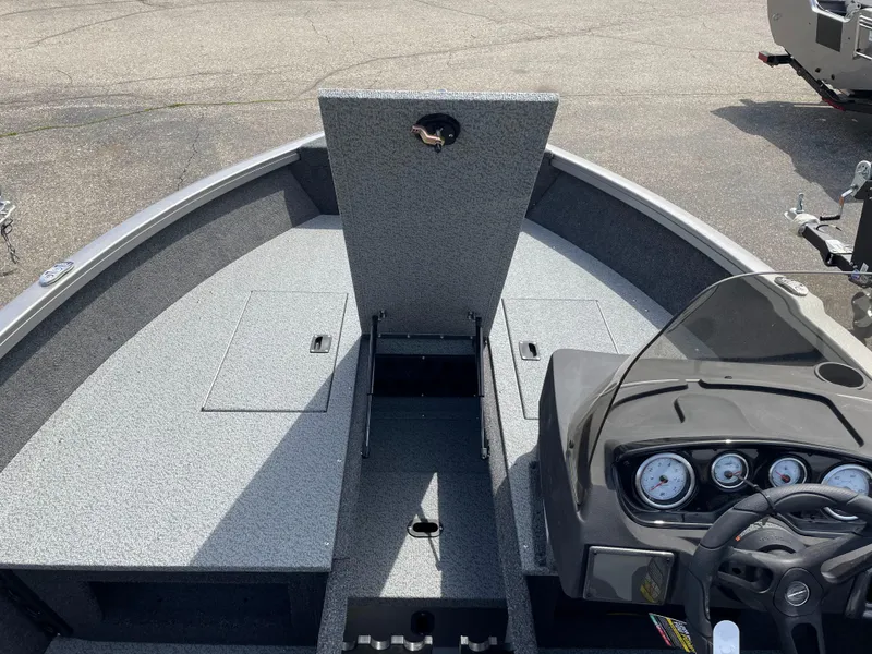 Slide: The Image of 2025 Crestliner 1750 Hawk SC boat interior with open storage compartment and dashboard. - 17