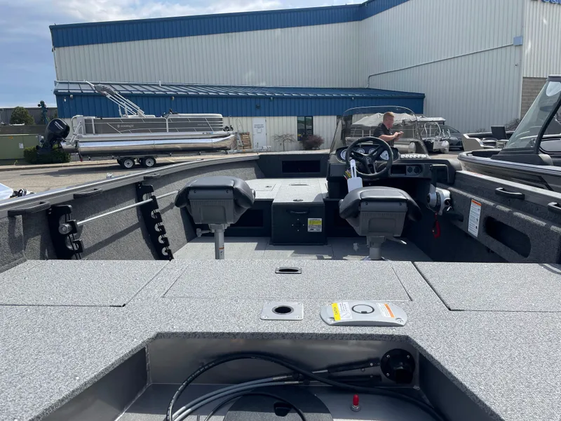 Slide: The Image of 2025 Crestliner 1750 Hawk SC boat interior with steering console and seating. - 2