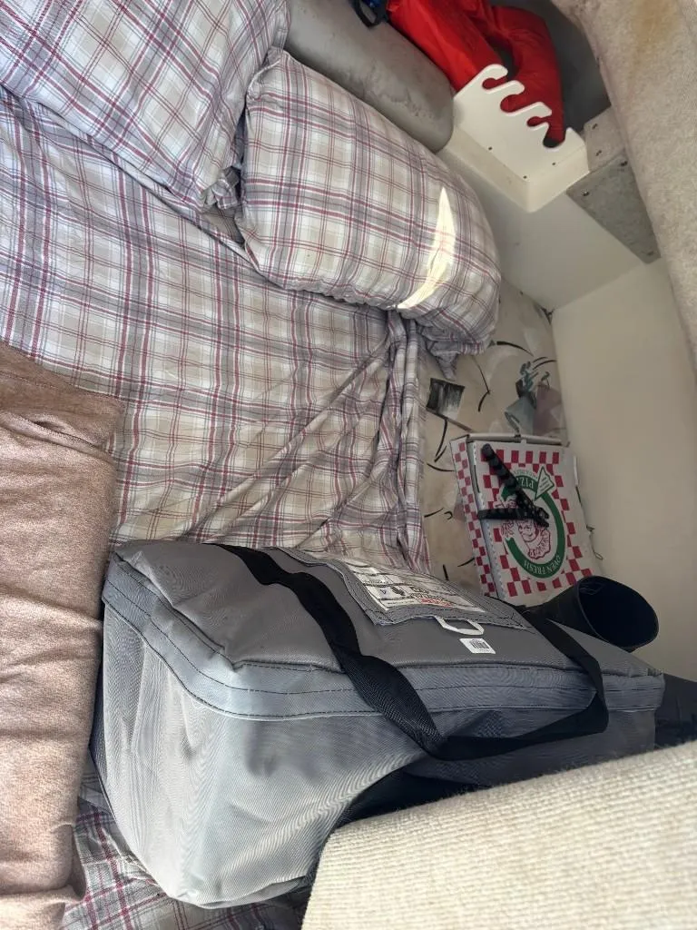 Slide: The Image of Interior of a 2001 World Cat 266 SC with plaid bedding and a gray bag. - 11