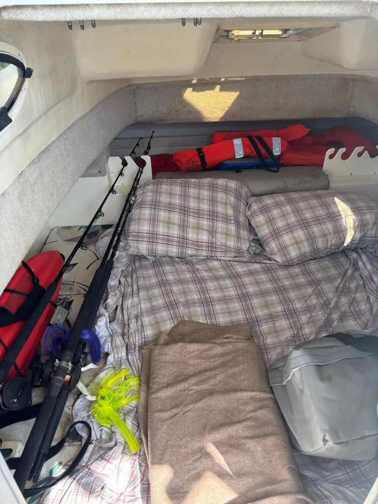 Slide: The Image of Interior of a 2001 World Cat 266 SC boat with fishing gear and plaid bedding. - 12