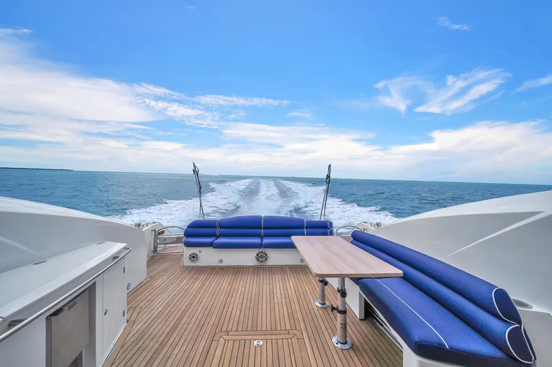 Slide: The Image of Sunseeker Predator 72 yacht deck with blue seating, cruising on open water. - 23