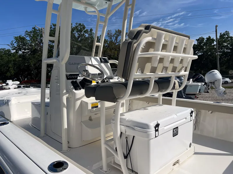 Slide: The Image of 2025 Key West 250 Bay Reef boat interior with seating and console, featuring a cooler. - 10
