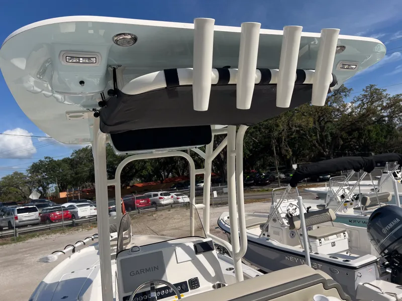 Slide: The Image of 2025 Key West 250 Bay Reef boat with T-top and rod holders, parked outdoors. - 18