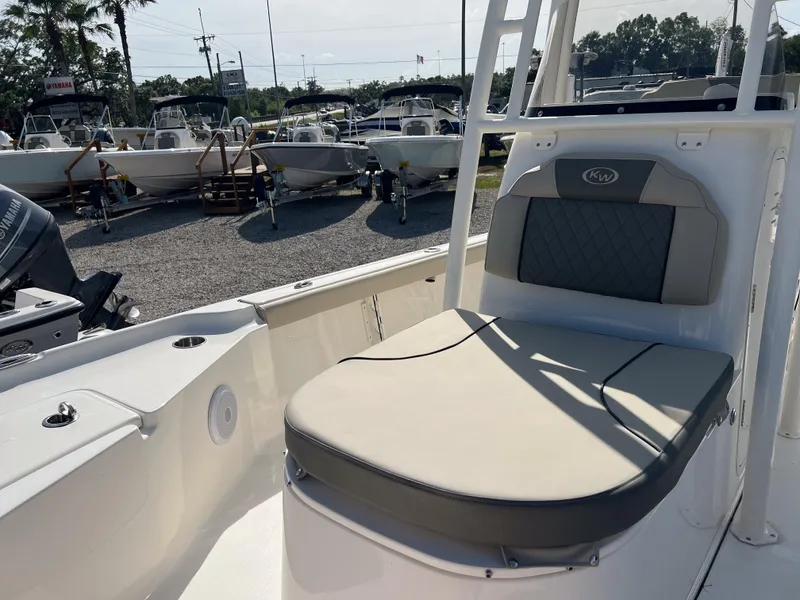 Slide: The Image of 2025 Key West 250 Bay Reef boat interior with cushioned seating, displayed in a boatyard. - 25