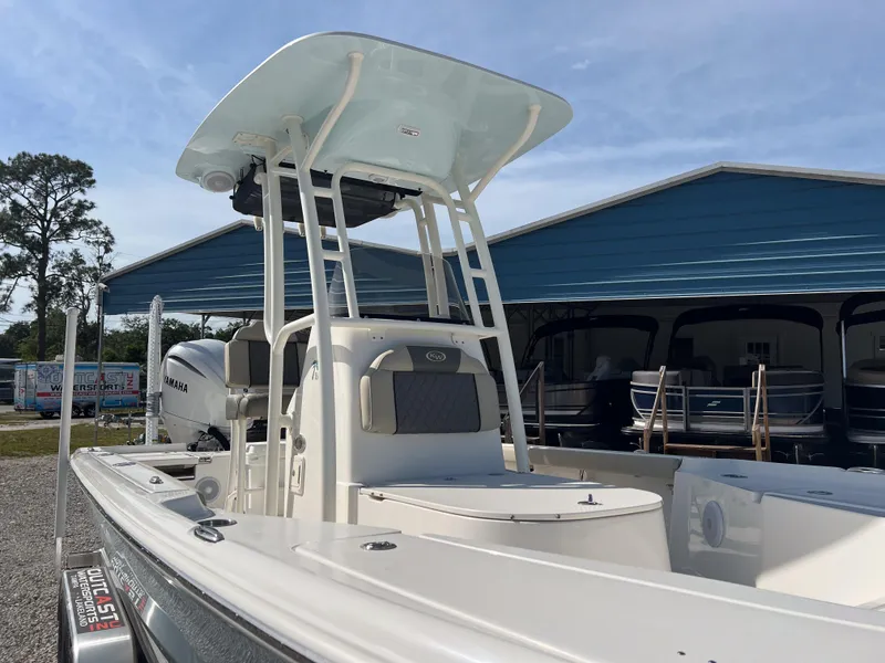 Slide: The Image of 2025 Key West 250 Bay Reef boat with T-top and Yamaha engine, parked outdoors. - 7