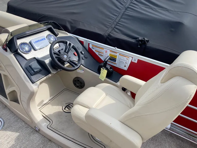 Slide: The Image of 2022 Premier 210 Sunsation RL boat interior with steering wheel and beige seating. - 11