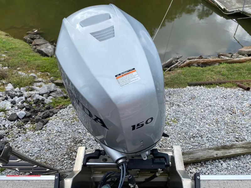 Slide: The Image of Outboard motor on a 2022 Premier 210 Sunsation RL by a lakeside. - 5