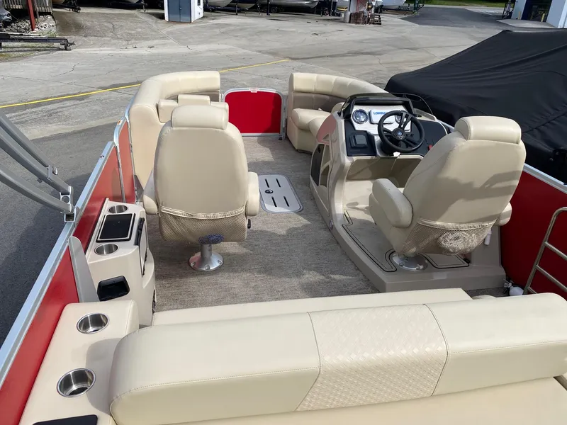 Slide: The Image of 2022 Premier 210 Sunsation RL pontoon boat interior with beige seating and steering console. - 7