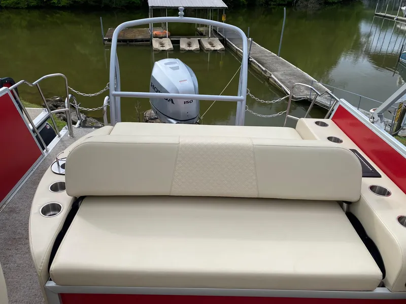 Slide: The Image of 2022 Premier 210 Sunsation RL boat with beige seating and outboard motor at dock. - 8