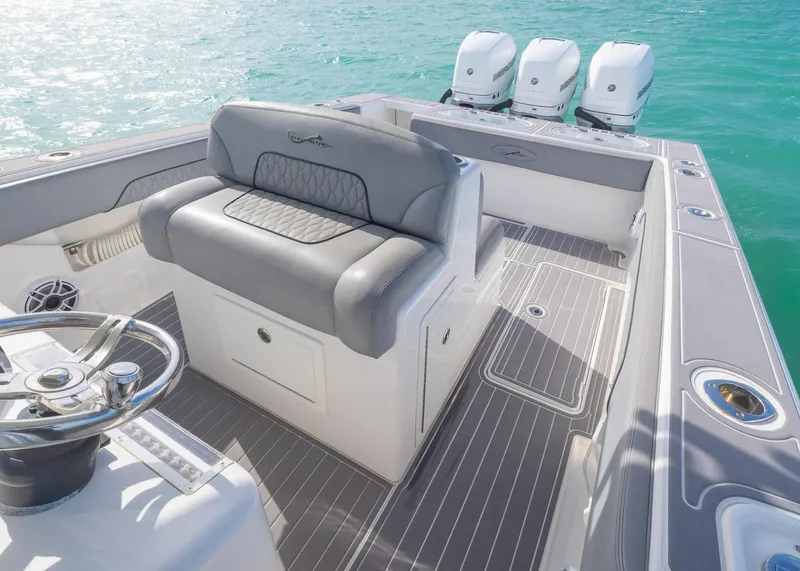 Slide: The Image of 2021 Blackwater 36 Sport boat interior with seating and triple outboard engines on turquoise water. - 12