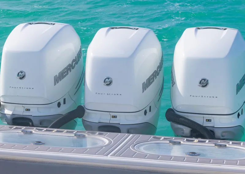 Slide: The Image of Triple Mercury outboard engines on a 2021 Blackwater 36 Sport boat in turquoise water. - 17